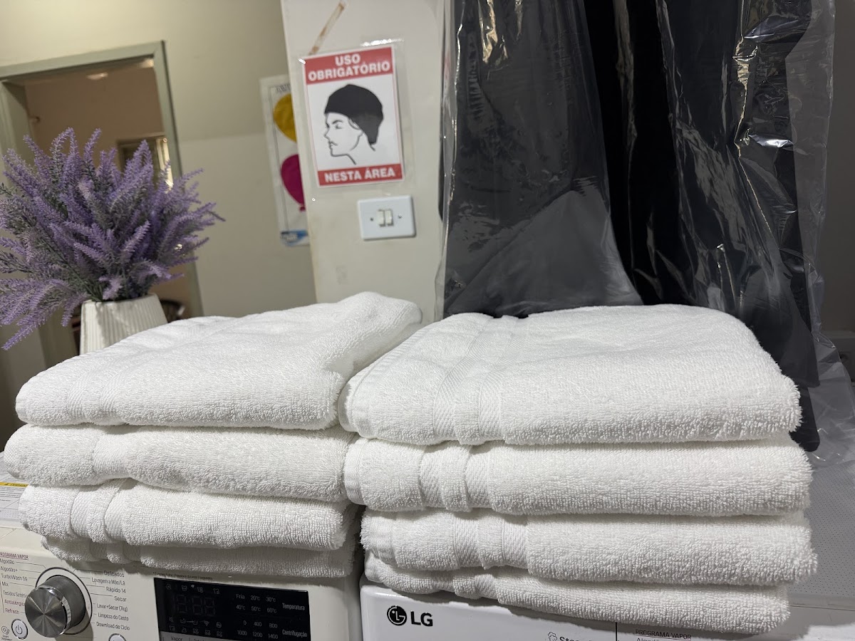 Toalhas dobradas e roupas protegidas na lavanderia Mister Clean de Birigui